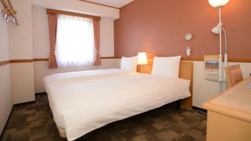 Toyoko Inn Sendai Higashi-guchi No.1 tesisinde bir odada yatak veya yataklar