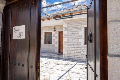 uma porta com um sinal em frente a um edifício em Zagori Home em Monodendri