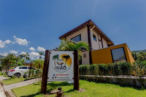 una señal frente a una casa con un edificio en Pousada Chalés do Julião, en Ubatuba