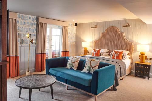 une chambre d'hôtel avec un lit et un canapé bleu dans l'établissement Hotel Du Vin Poole, à Poole