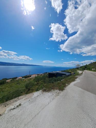 un chemin de terre à côté d'une nappe d'eau dans l'établissement Bella vista with jacuzzi 1, à Omiš