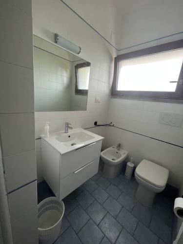 bagno con lavandino, servizi igienici e finestra di Villa Giannella a Orbetello