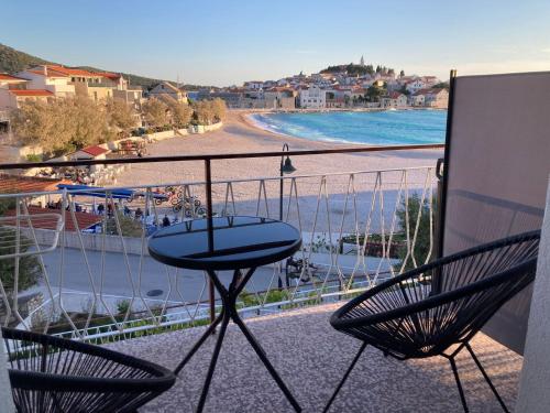 uma varanda com 2 cadeiras e vista para a praia em Rooms 22 - Beachfront em Primošten