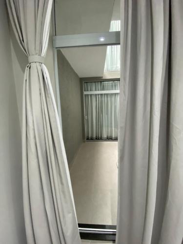 a curtain in a room with a window at Waikiki Apartament Ipanema in Rio de Janeiro