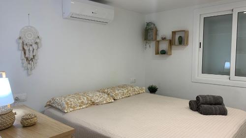 a white room with two beds and a window at Rodhes Playa B-1 in Roses