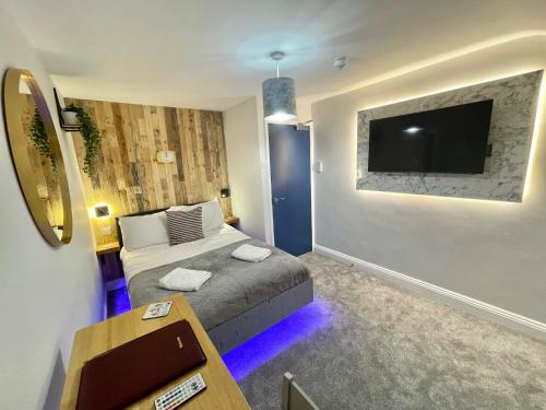 um quarto com uma cama e uma televisão de ecrã plano em Cloud9 Guest House - by Coastline Retreats - Newly Renovated, Beautiful Ensuite Rooms Near Seafront in Town Centre, Netflix, SuperFast WiFi, Communal Kitchen em Bournemouth