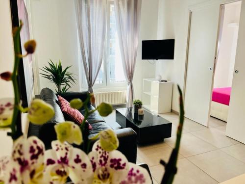 a living room with a couch and a table with flowers at Grazioso bilocale in centro storico in Verbania