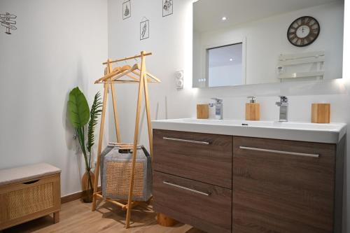 baño con lavabo y reloj en la pared en Appartement Design, en Fréjus