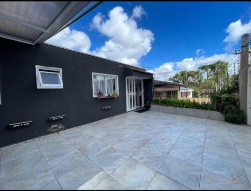 a black house with a large patio at Hostel AJBJ Turismo in Curitiba