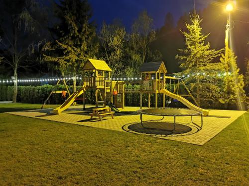 een speeltuin in een park 's nachts met verlichting bij POPASUL LU' VODĂ in Borşa