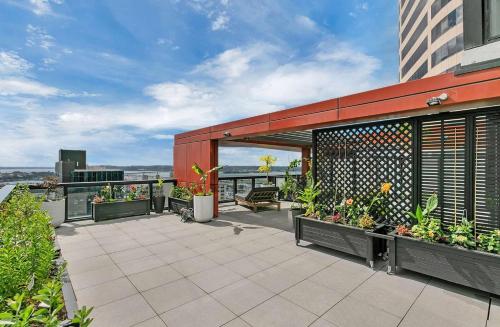 een patio met bloemen en planten op een gebouw bij City and view holiday home in Auckland