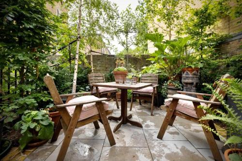 un patio avec une table, des chaises et un grill dans l'établissement Kings Cross, self-contained house & private garden, à Londres