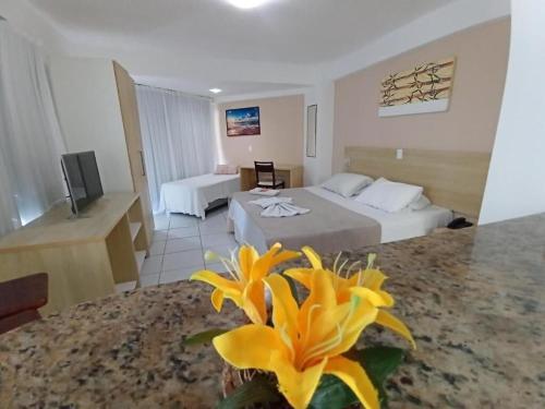 a hotel room with two beds and a yellow flower at Marsallis Praia JR 408 in Natal