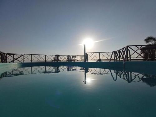 a bridge over a pool of water with the sun shining at Marsallis Praia JR 408 in Natal