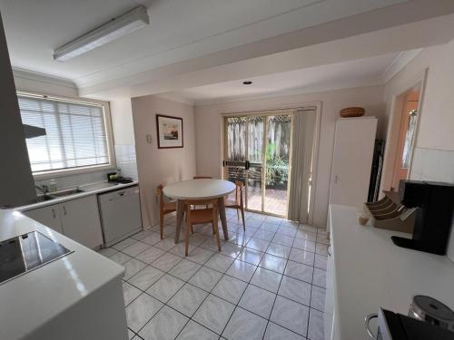 eine Küche mit einem Tisch und einem Esszimmer in der Unterkunft 3 Bedroom Town house near Gosford CBD Sleeps 6 plus in Gosford