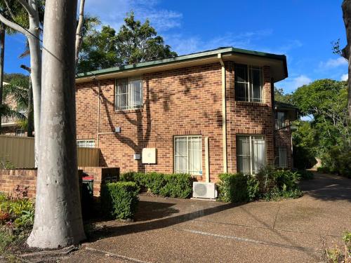 ein Backsteinhaus mit einem Baum davor in der Unterkunft 3 Bedroom Town house near Gosford CBD Sleeps 6 plus in Gosford