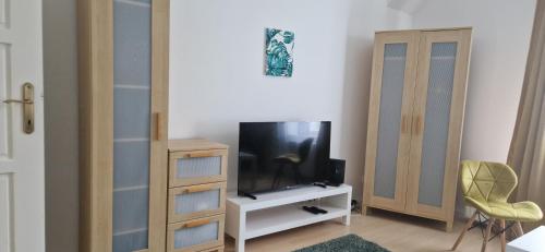 een woonkamer met een tv op een witte kast bij GOLD 3 in Sopron