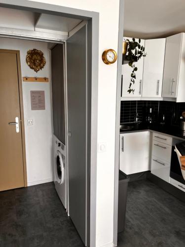 a kitchen with a door open to a washer and dryer at Une terrasse sur la mer in Crozon