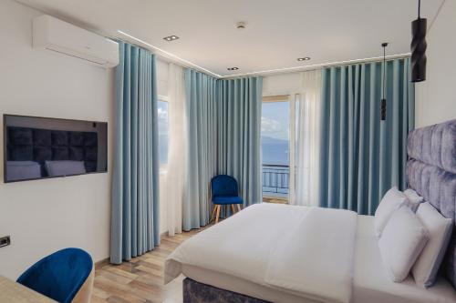 una camera d'albergo con un letto e una grande finestra di Asi Rooftop Hotel a Sarandë