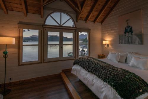 - une chambre avec un grand lit et une vue sur l'eau dans l'établissement Las Balsas Relais & Chateaux, à Villa La Angostura