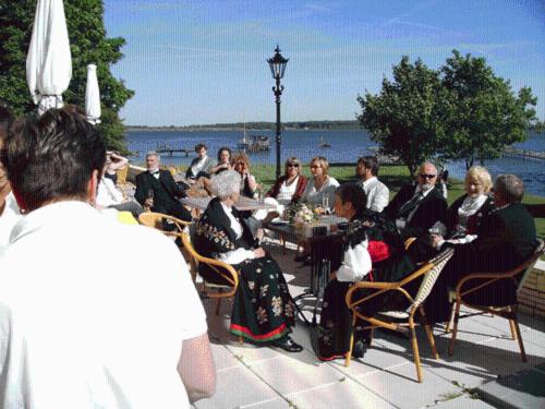 um grupo de pessoas sentadas numa mesa junto à água em Hotel Dänholm em Stralsund