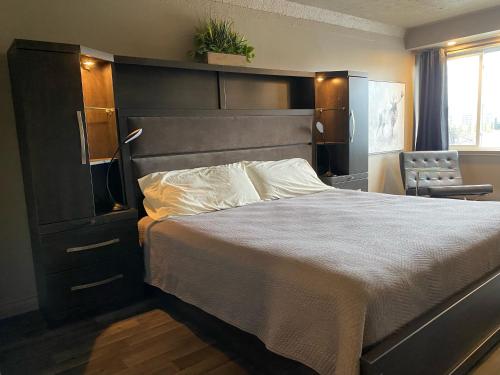 um quarto com uma cama grande e uma cadeira em Travelodge by Wyndham Drummondville em Drummondville