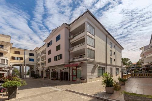 ein Apartmenthaus auf einer Straße mit wolkigem Himmel in der Unterkunft Studio Sirena in Izola