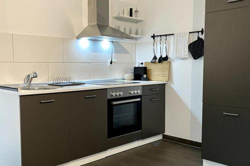 een kleine keuken met een fornuis en een wastafel bij Gemütliche Wohnung in ruhigem Wohngebiet in Aschaffenburg