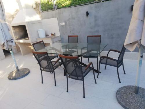 a glass table and chairs on a patio at Bika in Omiš