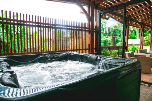 una vasca idromassaggio su un patio recintato di Villa Le Colonial Zen - T4 à 5 mn Aéroport a Sainte-Marie