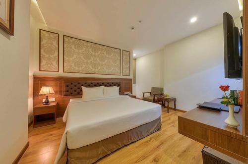 1 dormitorio con 1 cama grande y TV en Imperial Nha Trang, en Nha Trang