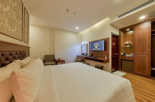 Habitación de hotel con cama grande y escritorio. en Imperial Nha Trang, en Nha Trang