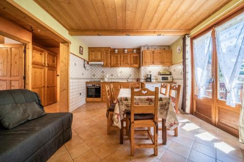 una cucina e una sala da pranzo con tavolo e divano di Apt Chénives 2 - Morzine a Morzine