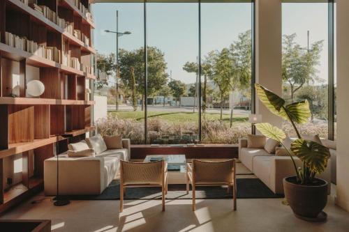 - un salon avec un canapé, des chaises et une grande fenêtre dans l'établissement Sabàtic Sitges Hotel, Autograph Collection, à Sitges