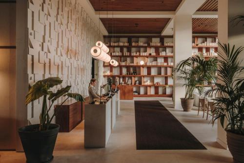 un hall d'un restaurant avec des plantes en pot dans l'établissement Sabàtic Sitges Hotel, Autograph Collection, à Sitges