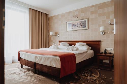 a hotel room with a bed with towels on it at Hotel Esperanto in Białystok