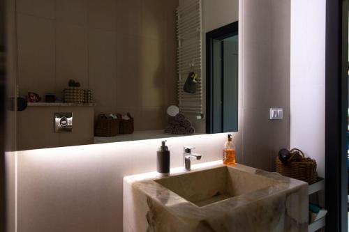 a bathroom with a marble sink and a mirror at BlueWater Apartment in Mikołajki