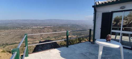 un osito de peluche sentado en una silla en un balcón en AL Miradouro do Outeiro, en Guarda