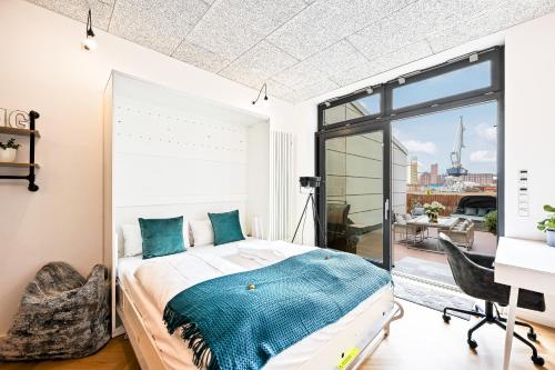 Schlafzimmer mit einem Bett, einem Schreibtisch und einem Fenster in der Unterkunft Lit Living - Luxus Loft - Box Spring - Air Con - BBQ - Panorama in Mannheim