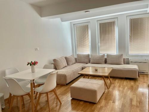 a living room with a couch and a table and chairs at Golden Apartment in Skopje