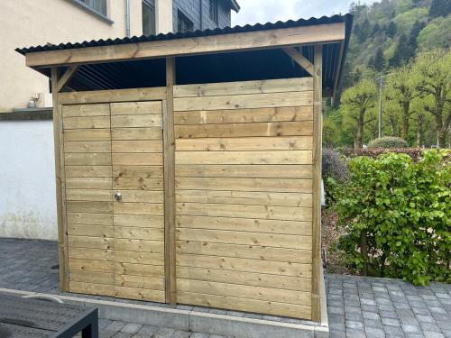 een houten garage met een dak erop bij Café du Pêcheurs in Bouillon