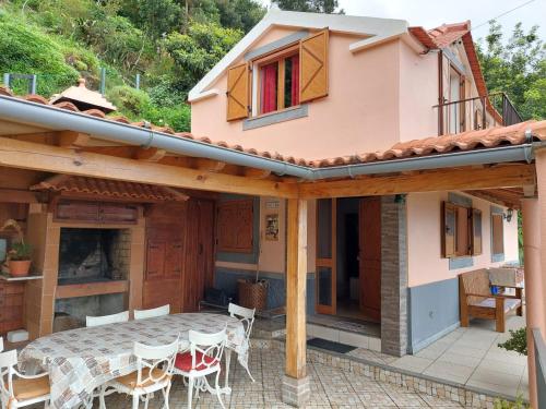 una casa y un patio con mesa y sillas en Fantatic Holiday House, en Ponta Delgada