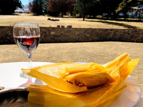 ein Glas Wein neben einem Teller mit Essen in der Unterkunft Casa en Tafí del Valle in Tafí del Valle