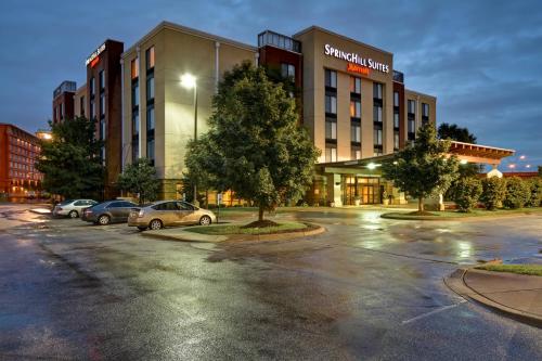 un parcheggio con auto parcheggiate di fronte a un edificio di SpringHill Suites Louisville Airport a Louisville