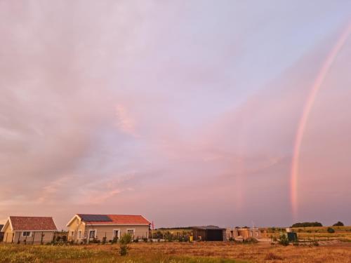 Un arcobaleno nel cielo sopra le case in un campo di 3 ruoniai a Palanga