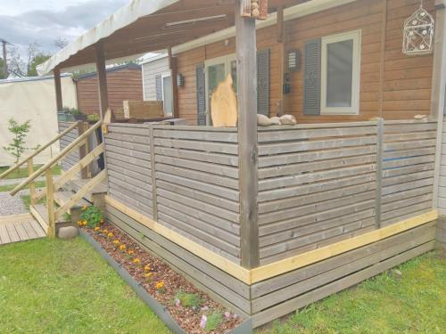 une terrasse couverte sur une petite maison dans l'établissement Grand Mobil Home 6 personnes climatisé avec 3 chambres et 2 salles de bains à Munster en Alsace, à Munster