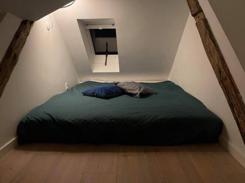 Un dormitorio con una cama verde en un ático en Hyggeligt lille byhus lige mellem havnen og bytorv, en Ringkøbing