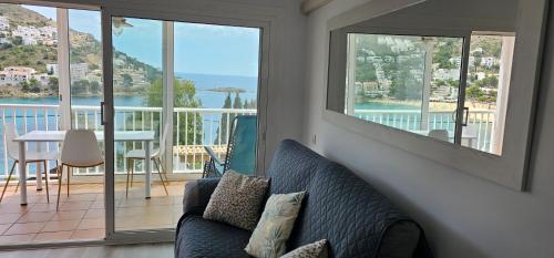 a living room with a couch and a balcony at Apartamento Canyelles playa in Roses