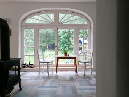 uma sala de jantar com uma janela arqueada e uma mesa e cadeiras em Villa Viriditas em Elbingerode