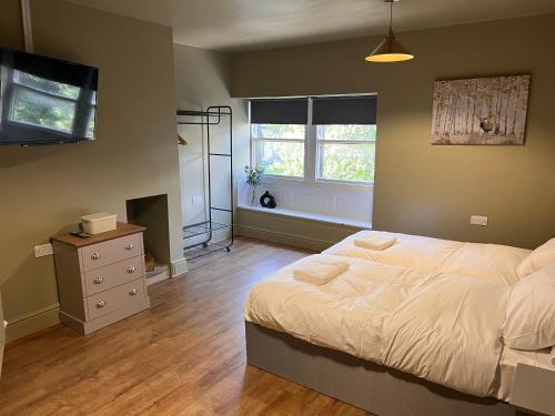 een slaapkamer met een bed, een dressoir en een raam bij The Ring O'Bells in Halifax